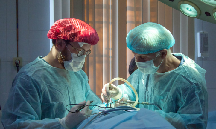 Two doctors performing surgery on a patient