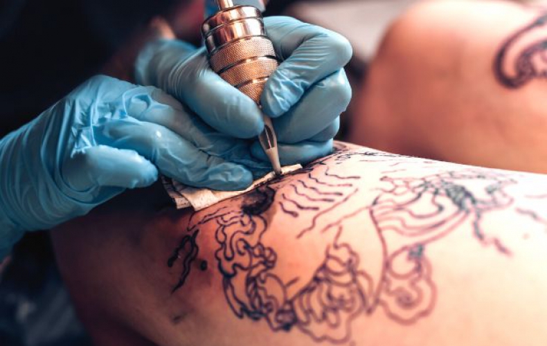 Tattoo Artist Making A Tattoo On A Shoulder